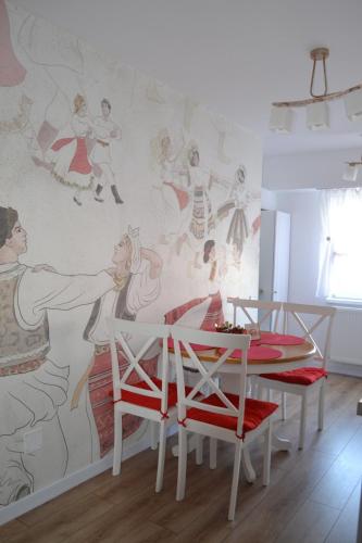 a dining room with a mural on the wall at Ania's Apartment in Horezu