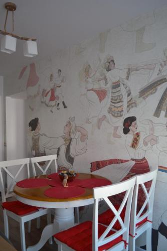 a dining room with a mural on the wall at Ania's Apartment in Horezu