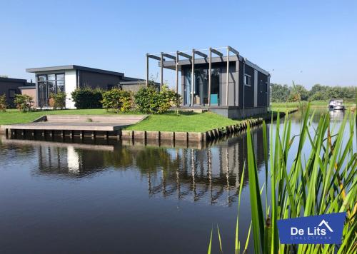 a house on the edge of a body of water at Chaletpark de Lits in Oostermeer