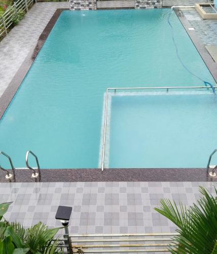 an empty swimming pool with blue water at Sky Lawns in Lonavala