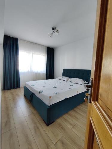 a bedroom with a blue bed in a room at Ania's Apartment in Horezu