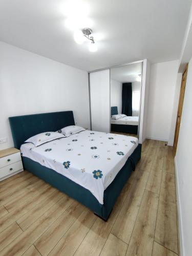 a bedroom with a bed and a large mirror at Ania's Apartment in Horezu