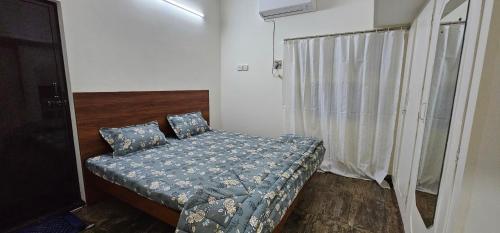 a small bedroom with a bed and a window at HOMESTAY - AC 3 BHK NEAR AlRPORT in Chennai