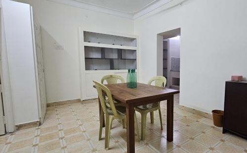 a dining room with a wooden table and chairs at HOMESTAY - AC 3 BHK NEAR AlRPORT in Chennai