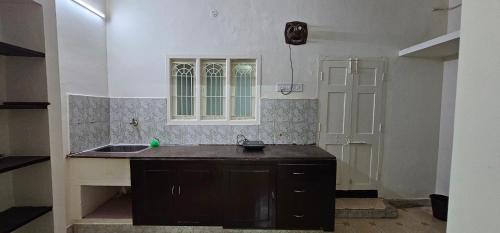 an empty kitchen with a sink and a window at HOMESTAY - AC 3 BHK NEAR AlRPORT in Chennai