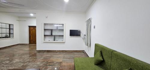 a room with a green couch and a wall at HOMESTAY - AC 3 BHK NEAR AlRPORT in Chennai