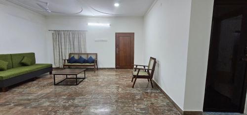 a living room with a green couch and chairs at HOMESTAY - AC 3 BHK NEAR AlRPORT in Chennai