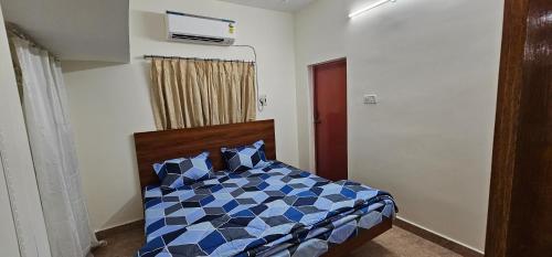 a bedroom with a bed with a blue at HOMESTAY - AC 3 BHK NEAR AlRPORT in Chennai