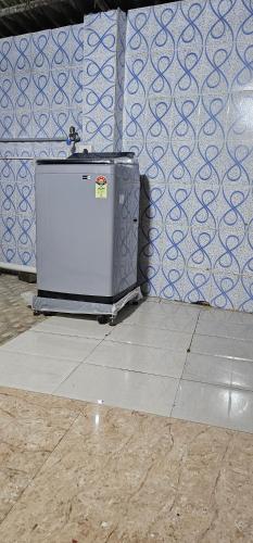 a refrigerator sitting on the floor next to a wall at HOMESTAY - AC 3 BHK NEAR AlRPORT in Chennai