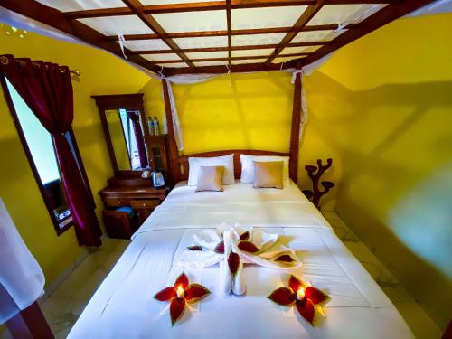 ein Schlafzimmer mit einem Bett mit Blumen darauf in der Unterkunft Ananda Homestay Lemukih in Singaraja
