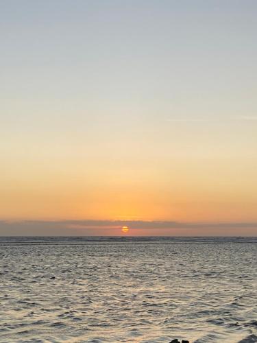 zachód słońca nad oceanem i słońce w oddali w obiekcie Gili pelangi w mieście Mataram