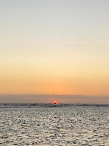 zachód słońca nad oceanem i słońce na horyzoncie w obiekcie Gili pelangi w mieście Mataram