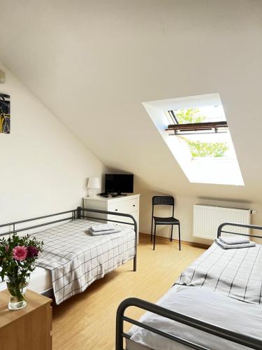 a attic bedroom with two beds and a skylight at Penzion Sofi in Prague