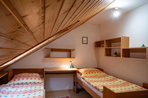 a room with two beds and a desk in a attic at Penzion Eva Krnov in Krnov