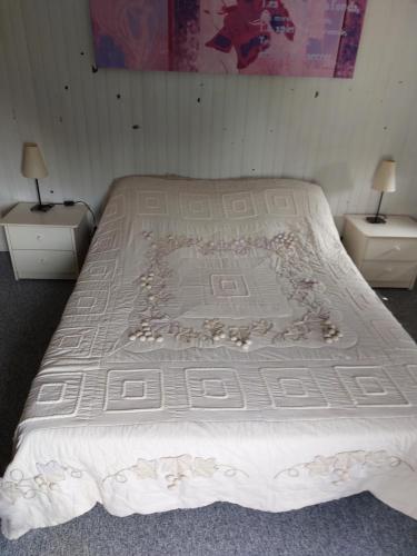 łóżko w pokoju z dwoma stołami i dwoma lampami w obiekcie La Quiétude w mieście Cotignac