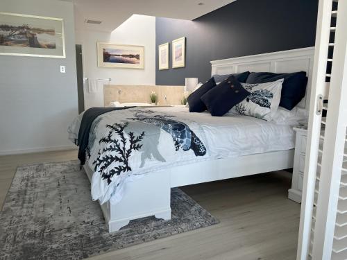 a bedroom with a white bed with a black and white blanket at Beachside Villa 7.1 in Mandurah