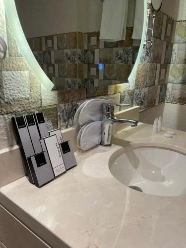 بريفير للأجنحة الفندقية Privere Hotel Suites في الرياض: حمام مع حوض ومرآة ومغسلة