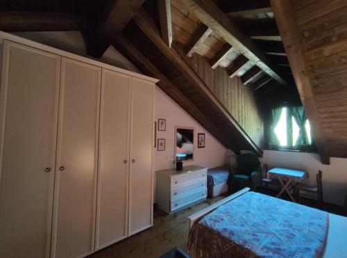 a bedroom with a bed and a dresser in a room at La dimora delle corti in Vanzone