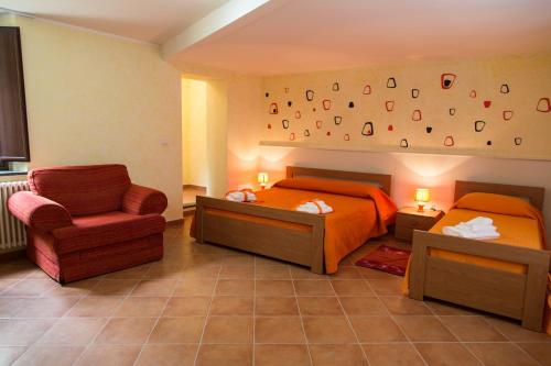 - une chambre avec deux lits et une chaise dans l'établissement Le Stanze del Re, à Lamezia Terme