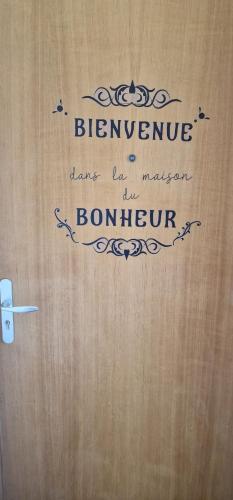 un panneau sur une porte en bois avec les mots bernumencerencerencerence dans l'établissement T3 Annemasse 4eme étage Proche Genève, à Annemasse