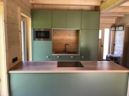 a kitchen with green cabinets and a sink at Das Grünhaus - Dein Chalet in Grünau im Almtal in Grünau im Almtal