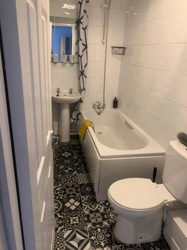 een badkamer met een bad, een toilet en een wastafel bij hewitt place in Crewe
