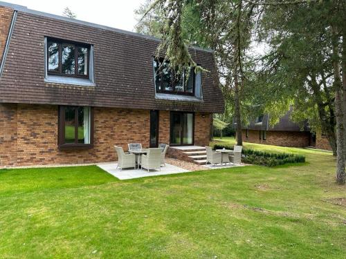a house with chairs and a table in the yard at One Dunbar Court Gleneagles Village in Auchterarder