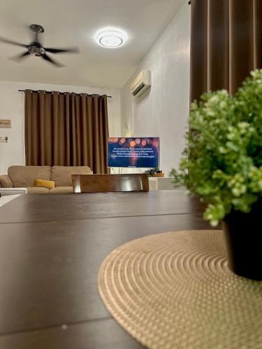 a living room with a table with a potted plant at Mijanna Guesthouse - Johor Bahru in Johor Bahru