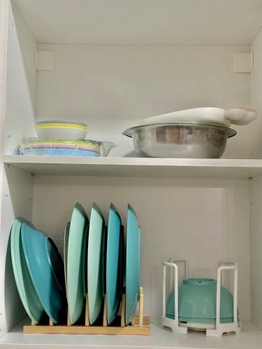 a shelf with blue bowls and plates on it at Mijanna Guesthouse - Johor Bahru in Johor Bahru