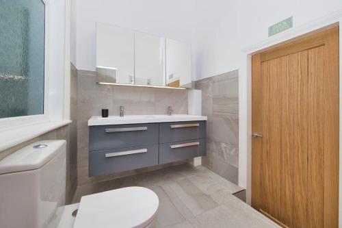 a bathroom with a white toilet and a sink at Stylish beachfront apartment in historic Deal in Kent