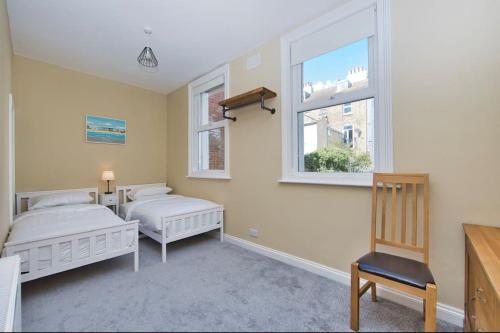 1 dormitorio con 2 camas y ventana en Stylish beachfront apartment in historic Deal en Kent