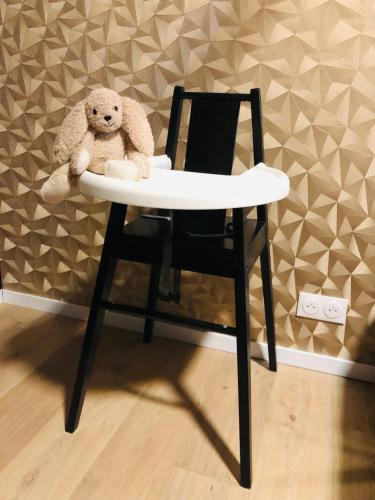 a teddy bear sitting in a chair with a table at Gîte "Le Loft" in Chamblet