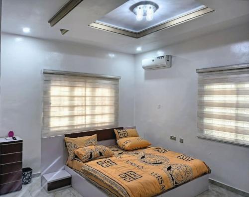 a bedroom with a bed in a room with windows at BBAN-Luxurious 4 Bedroom House in Lekki Ajah Lagos in Lekki