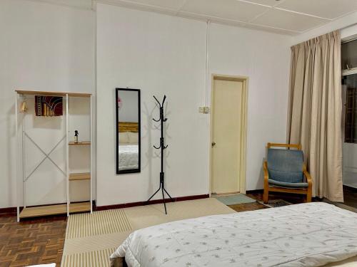 a bedroom with a bed and a mirror and a chair at Mijanna Guesthouse - Johor Bahru in Johor Bahru