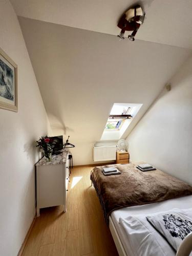 a attic bedroom with a bed and a window at Penzion Sofi in Prague