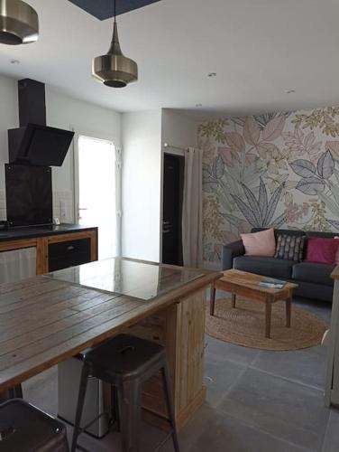 un salon avec une table et un canapé dans l'établissement Maison d'hôtes cosy & agréable à 5min du Futuroscope, à Saint-Georges-lès-Baillargeaux