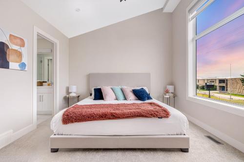 - une chambre avec un grand lit et une grande fenêtre dans l'établissement Modern Altadore Home 3 Br Fireplace Sleeps 8, à Calgary