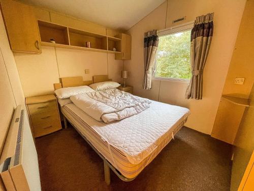 um pequeno quarto com uma cama e uma janela em Lovely 6 Berth Caravan At Skipsea Sands Park In Yorkshire Ref 41053sf em Barmston