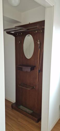 a mirror on a wooden wall in a room at Gemütliche Wohnung am Wald in Loosen