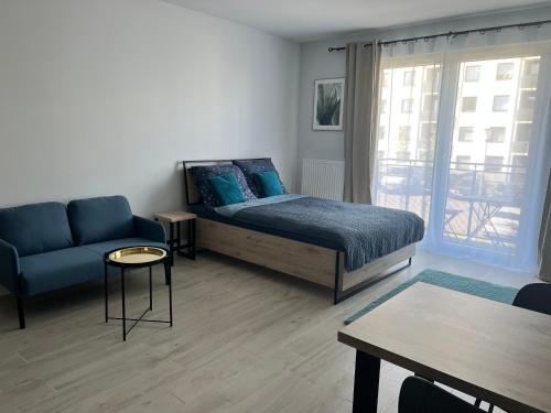 sypialnia z łóżkiem, kanapą i stołem w obiekcie Harmonia Apartments w Szczecinie