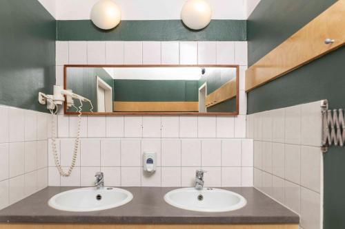ein Badezimmer mit 2 Waschbecken und einem Spiegel in der Unterkunft EastSeven Berlin Hostel in Berlin