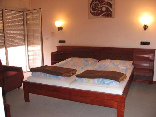 1 dormitorio con 1 cama con 2 almohadas en Pannon Panzió Restaurant, en Pannonhalma