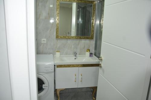 y baño con lavabo y lavadora. en Hera Emlak en Kırac