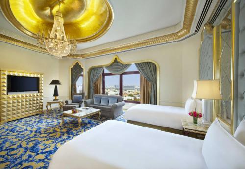 une chambre d'hôtel avec deux lits et un canapé dans l'établissement Waldorf Astoria Jeddah - Qasr Al Sharq, à Djeddah