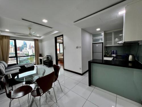 吉隆坡的住宿－Casa Residency Apartment，厨房以及带桌椅的起居室。