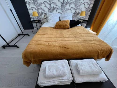 - un grand lit avec 2 serviettes blanches dans l'établissement Esprit Panthère, à Mulhouse