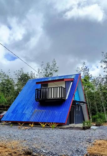 een huis met een blauw dak en een balkon bij Nour Homestay in Kaki Bukit