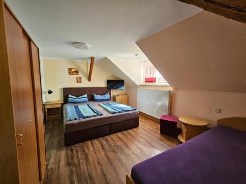 ein Schlafzimmer mit einem Bett im Dachgeschoss in der Unterkunft Pension Zur Kutscherstube in Colditz
