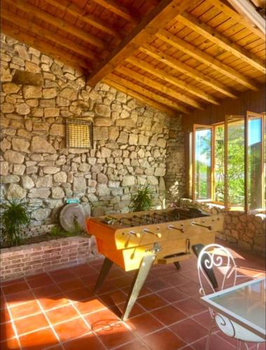un salon avec une table et un mur en pierre dans l'établissement Gîte de la fontaine, à Sainte-Agathe