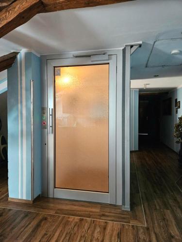 a large glass door in a room with wooden floors at Pension Zur Kutscherstube in Colditz